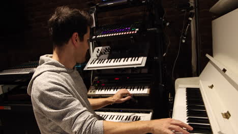 Male-Composer-Playing-On-keyboards-Creating-Music-Inside-Studio