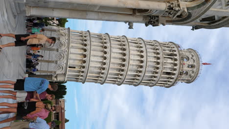 Vertikaler-Schuss-Des-Schiefen-Turms-Von-Pisa-Mit-Touristen-Im-Vordergrund-In-Der-Toskana,-Italien
