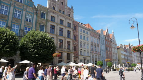 Colorful-Townhouses-of-Gdansk-Historic-Old-Town-City-Center,-Tilt-Down-Revealing-Tourists-in-the-Street