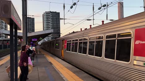 Passengers-waiting-at-South-Brisbane-station,-Queensland-translink-railway-train-arrived-at-the-platform-at-sunset-hours