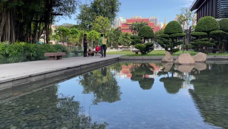 Hermosa-Reflexión-Sobre-El-Agua-Y-La-Gente-Charlando-En-El-Parque-Zhong-Shang-En-Singapur