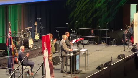 Selected-representatives-receiving-their-citizenship-certificate-from-Lord-Mayor-Adrian-Schrinner-on-stage,-Brisbane-supersized-ceremony-due-to-pandemic-at-Brisbane-convention-and-exhibition-centre