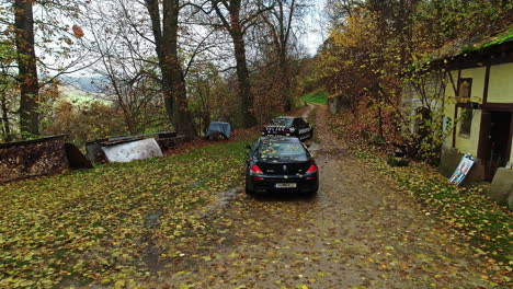 Black-color-BMW-E39-and-M6-cars-driving-in-autumn-forest-during-fall