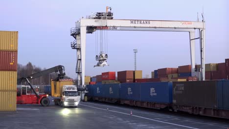 Volvo-truck-unloading-the-yellow-container-at-the-transportation-terminal-in-Senov-u-Ostravy-with-Metrans-crane-at-dusk
