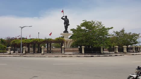 Nicolau-dos-Reis-Lobato-historical-statue,-national-hero-of-East-Timor,-and-traffic-in-the-capital-city-Dili,-Timor-Leste,-Southeast-Asia