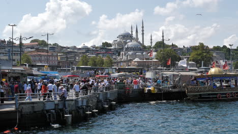 Typical-crowded-pier-scene-in-Istanbul,-Süleymaniye-Mosque-in-background