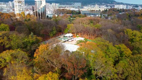 Drone-flying-forwards-revealing-open-air-leisure-center-in-middle-of-big-park-in-Varna-city,-Bulgaria