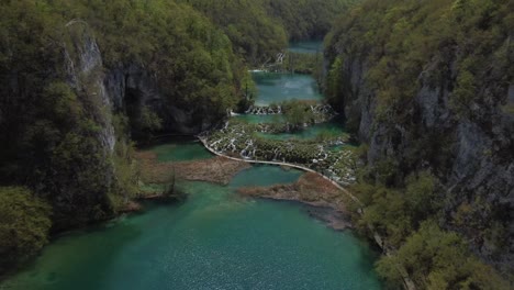Drone-shot-of-Plitvička-Nationalpark-in-Croatia---drone-is-flying-against-the-stream-of-the-blue-river-pools
