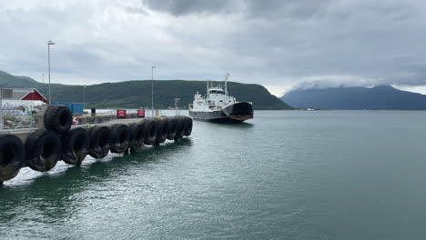 Norwegian-ferry-Trondenes-arrives-at-the-pier-in-Nesna-and-opening-the-baug-on-a-moody-day-during-summer