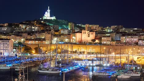 Marseille-old-port-at-night-with-boats-and-illumunated-historic-buildings-in-timelapse