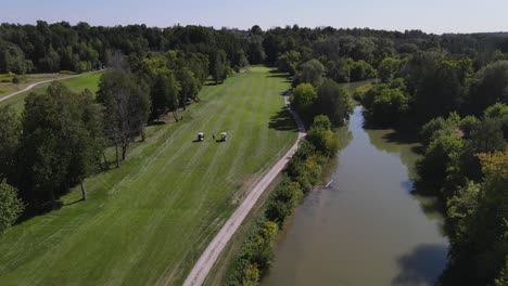 wide-sweeping-drone-shot-over-a-golf-course-flying-cinematically-right-to-a-golfer-teeing-off