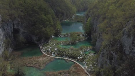 Drone-shot-of-Plitvička-Nationalpark-in-Croatia---drone-is-flying-above-the-beautiful-blue-river-pools