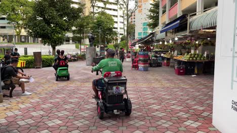 Grab-food-riders-ride-their-Personal-Mobility-Aids-for-food-delivery-in-Chong-Pang-City,-Yishun,-Singapore