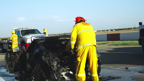 Firefighters-extinguish-and-spray-with-water-burning-car-following-serious-car-accident-on-a-race-track