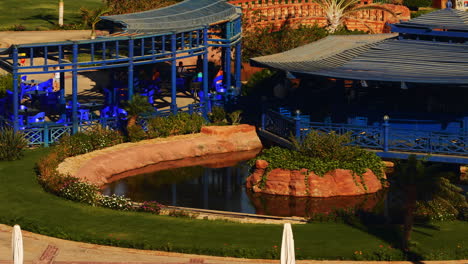 Outdoor-Cafe-Restaurant-Terrace-in-Hotel-Resort-Garden-During-Summer-Sunny-Morning-in-Egypt,-Patio-and-Pond