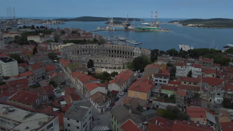 Drone-shot-of-the-Amphitheater-in-Pula,-Croatia---drone-is-approaching-the-ancient-Roman-site-from-far