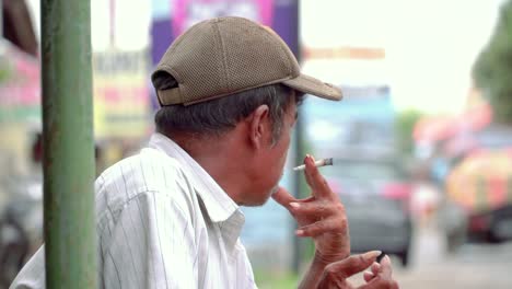 Slow-motion---close-up-shot-of-a-poor-man-is-smoking-cigarettes-on-the-side-of-road
