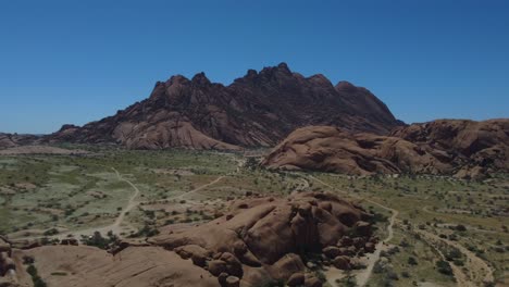 Toma-De-Un-Dron-De-Un-Hermoso-Paisaje-En-Namibia---Un-Dron-Está-Ascendiendo-Y-Mirando-Hacia-Las-Montañas-Spitzkoppe