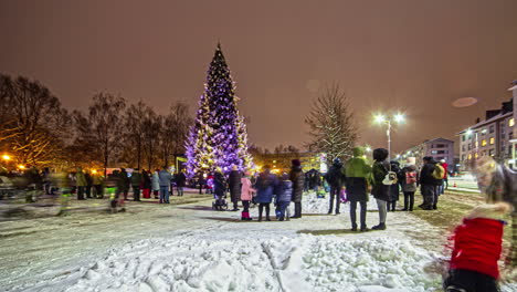 Villagers-enjoy-the-Christmas-tree-lights-and-festive-display-at-the-town-square---time-lapse