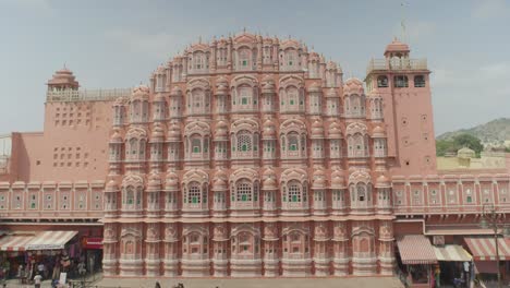 Hawa-Mahal-Sonnige-Weite-Aufnahme-Mit-Verkehr-Im-Vordergrund-Und-Blick-Auf-Schöne-Beliebte-Touristenattraktion-In-Jaipur,-Rajasthan,-Indien,-Sonniger-Tag-Des-Klaren-Himmels