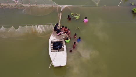 Aerial-Overhead-View-Of-Locals-Wading-In-Flooded-Waters-Fishing-In-Sindh,-Pakistan
