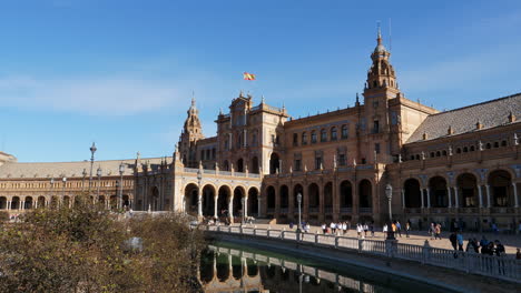 Main-Facade-of-Plaza-de-España-Half-Cirlcle-Building,-Tourist-Visiting-Seville-on-a-Beautiful-Sunny-Day