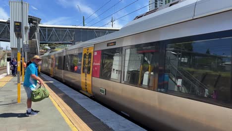 Passagiere,-Die-An-Gleis-4-Warten,-Zug,-Der-Am-Bahnhof-Bowen-Hills-Ankommt,-Fahrt-In-Die-Innenstadt-An-Einem-Sonnigen-Tag,-öffentliche-Verkehrsmittel-Der-Translink-Queensland-Railway,-Brisbane-City,-Australien