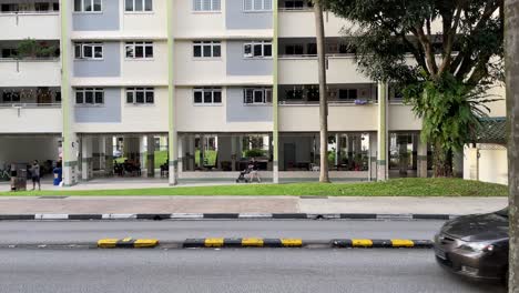Streetview-Mit-Fahrenden-Fahrzeugen-Vor-Dem-Hintergrund-Der-Wohnsiedlung-In-Yishun,-Singapur