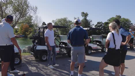 golfers-outside-standing-around-in-a-croud-waiting-by-their-golf-carts
