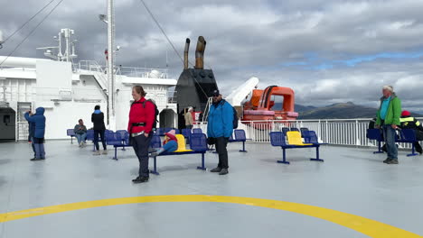 Happy-tourists-enjoying-the-view-on-the-outside-ferry-deck-while-crossing-Vestfjorden-in-Norway