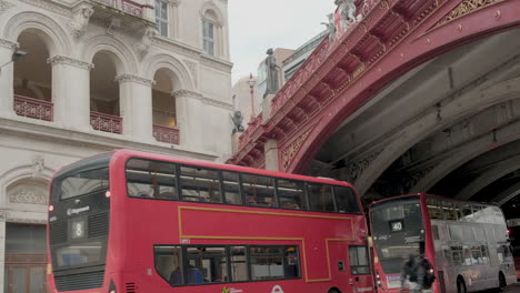 Holborn-Viaduct-with-Red-London-Bus’s-Passing-underneath,-Historic-London-Landmark-and-Victorian-Architecture-and-Engineering