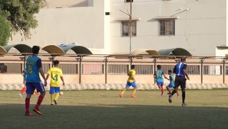 Vista-En-Cámara-Lenta-De-Jugadores-De-Fútbol-Corriendo-En-Un-Partido-Local-En-Karachi,-Pakistán