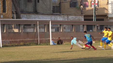 Vista-En-Cámara-Lenta-Del-Jugador-De-Fútbol-Corriendo-Hacia-El-Gol-Con-La-Pelota-Solo-Para-Ser-Ensuciado-En-Un-Partido-Local-En-Karachi