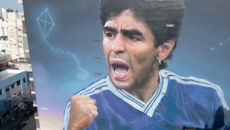 Painted-wall-mural-of-hand-of-god-Diego-Maradona,-artist-Martin-Ron-has-perfectly-depicted-the-urging-facial-expression-he-had-during-World-Cup-final-against-Germany-in-1990,-aerial-dolly-in-shot