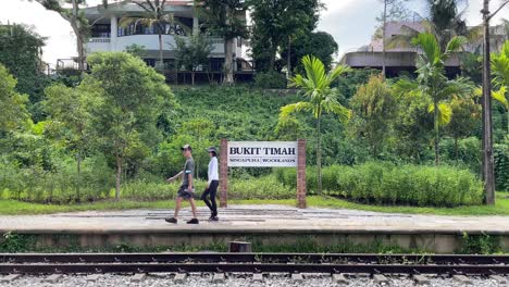 Excursionistas-En-El-Corredor-Ferroviario-Contra-La-Señalización-De-La-Estación-De-Tren-Bukit-Timah-En-Singapur