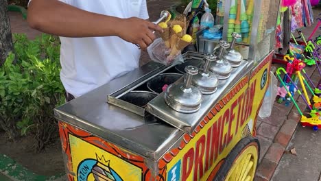 Street-food-vendor-sells-ice-cream-from-colorful-cart,-Manila,-Philippines