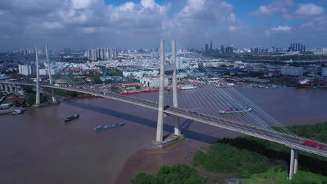Aerial-view-of-Phu-My-Bridge-over-Saigon-river-with-road-and-river-transportation-on-a-sunny-day