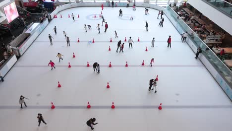 Chinesische-Teilnehmer-Jeden-Alters-Genießen-Und-Lernen-Indoor-Eislaufen-In-Einem-Einkaufszentrum-In-Hongkong
