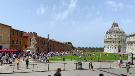 Piazza-dei-Miracoli-with-tourists-walking-around-historic-buildings-in-Pisa-Italy