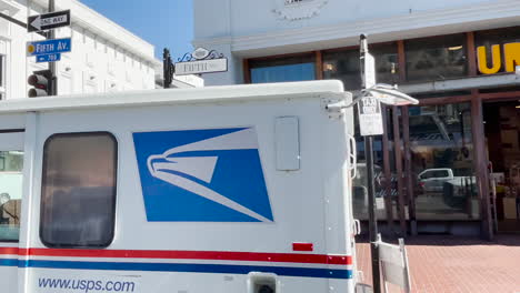 Stores-and-USPS-mail-truck-in-downtown-San-Diego,-driving-through-town,-POV-style