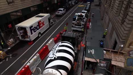 Aerial-view-over-a-concrete-lift-and-a-mixer-truck,-at-a-construction-site-in-middle-of-high-rise-in-Midtown,-Manhattan,-NYC,-USA