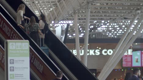 slow-motion-shot-of-three-ladies-on-the-escalator-in-brasilia-international-airport