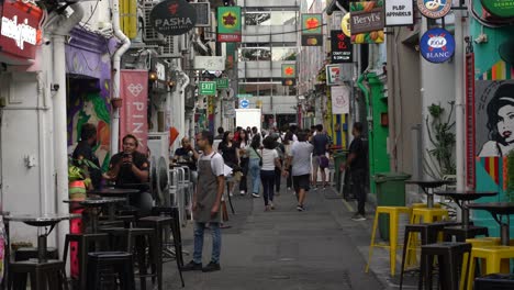 People-walking-and-chit-chatting-in-outdoor-pubs-at-Haji-Lane,-Singapore