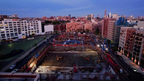 Aerial-view-over-a-high--rise-construction-site,-sunny-evening-in-Brooklyn,-NY---tilt,-drone-shot