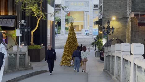 Gente-China-Caminando-Por-La-Entrada-Del-Hotel-Con-Una-Enorme-Instalación-De-árboles-De-Navidad-Por-La-Noche