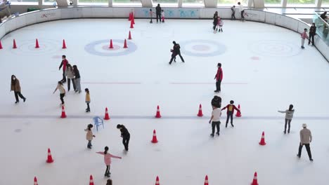 Chinesische-Teilnehmer-Aller-Altersgruppen-Aus-Der-Vogelperspektive-Beim-Eislaufen-In-Der-Halle-In-Einem-Einkaufszentrum-In-Hongkong