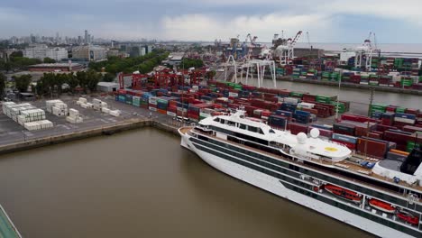 Forward-aerial-of-cruise-ship-at-industrial-harbor-in-Buenos-Aires
