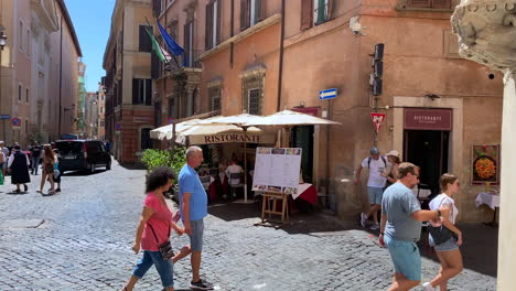 Tourists-walk-through-historic-streets-of-Rome-Italy-near-an-Italian-restaurant