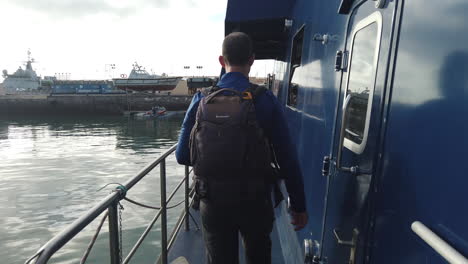 man-with-a-backpack-walks-through-the-deck-of-the-maritime-patrol-boat-of-the-customs-police
