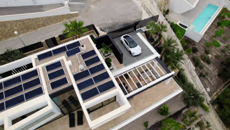 Aerial-Birds-Eye-Descending-Shot-Of-Solar-Panels-On-Rooftop-Of-Luxury-Home-On-Hilltop-In-Calp,-Spain